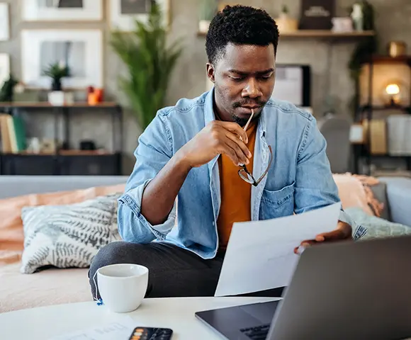 a man reading a document in his living room